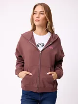 Canguro con cierre frontal de la marca Rusty, en color beige. Presenta capucha, bolsillos tipo canguro y logo bordado en el pecho.