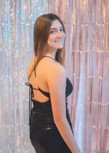 Vestido negro de fiesta, corte mini, con top tipo corsé con costuras fruncidas y breteles finos que se atan en la espalda. Elástico en la cintura trasera.