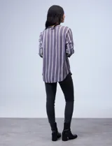 Camisa celeste con rayas verticales blancas y azules, cuello mao, escote en V y cierre frontal con botones.