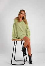Conjunto compuesto por camisa oversize de manga larga con puños y short con cintura elástica. Ambas prendas presentan un diseño de rayas verticales tono sobre tono con textura suave y fluida.