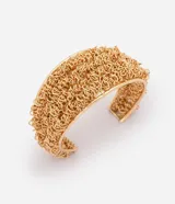 Pulsera rígida color dorado, formato abierto y estructura curva, con diseño tridimensional de hilos entrelazados en efecto alambrado.