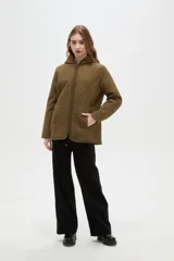 Campera de diseño capitoneado con cierre frontal, capucha integrada y bolsillos laterales. Presenta un corte entallado y mangas largas.