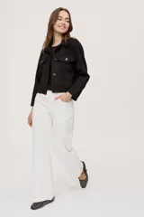 Pantalón de tiro medio y calce wide leg, color blanco, con diseño clásico de cinco bolsillos y cierre frontal con botón y cremallera.