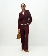 Pantalón wide leg de cintura alta, confeccionado en una mezcla de viscosa y poliéster. Presenta cierre frontal con dos botones, trabillas para cinturón y bolsillos laterales.