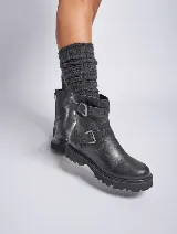 Bota de cuero color marrón con hebillas metálicas, caña media y suela track color negro.