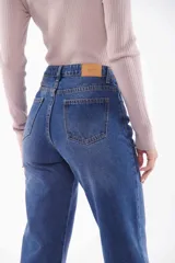 Pantalón de jean negro de corte recto, con cintura alta y ruedo doblado.