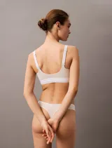 Corpiño deportivo Calvin Klein Icon Modal Mesh, color blanco roto, con tirantes anchos y banda elástica inferior con logo repetido.