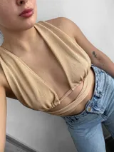 Top negro con escote halter y tiras cruzadas en el abdomen.