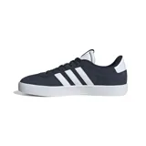 Championes Adidas modelo VL Court, de diseño urbano inspirado en el skate. Presentan una parte superior de gamuza en color azul marino con las tres bandas características de la marca en cuero sintético blanco y suela de goma vulcanizada blanca.