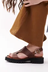 Sandalia de cuero sintético color camel, con plataforma track y hebilla metálica.