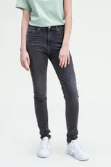 Pantalón de jean negro gastado, tiro alto, corte ajustado en cadera y muslos, y pierna skinny.