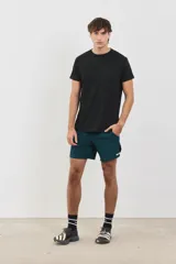 Short deportivo de hombre, confeccionado en tejido liviano y respirable con spandex para mayor movilidad. Presenta cintura elástica de 4 cm, bolsillos laterales y logo de la marca estampado en el ruedo. Diseño de largo medio con aberturas laterales.