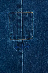 Chaleco de denim azul con cierre cruzado con botones metálicos.