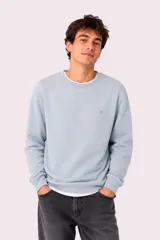 Buzo deportivo gris melange con cuello redondo, mangas largas y puños elásticos acanalados. Cuenta con un pequeño logo bordado en el pecho.