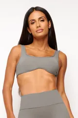 Top deportivo gris con escote cuadrado, breteles anchos y calce ajustado. Incluye forro interno y apertura para almohadilla removible.
