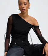 Blusa ajustada de tul negro con diseño asimétrico de un solo hombro. Presenta mangas largas transparentes, fruncido lateral y una aplicación vertical de encaje que aporta textura.