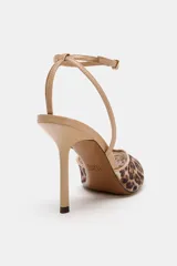 Zapato de tacón alto fino y destalonado, confeccionado en mesh con estampado animal print tipo leopardo. Presenta acabado en punta fina y tiras finas con hebilla ajustable a la pulsera del tobillo.