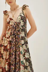 Vestido largo con escote en V profundo y tirantes con volados. Presenta un diseño patchwork con diferentes estampados florales y texturas en tonos tierra, negro y dorado metalizado.
