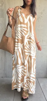Vestido largo color beige con estampado de hojas blancas, de tirantes finos y corte recto.