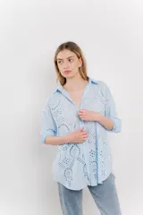 Camisa celeste de algodón liviano con bordado calado tipo broderie, manga larga con puño angosto y botones al frente.
