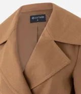Campera pesada de estructura firme, color marrón, con cuello amplio de solapa alargada, cierre cruzado con botones, mangas largas y bolsillos delanteros. Presenta un canesú sobrepuesto en la espalda con pliegue central.