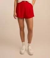 Short blanco de viscosa texturizada, modelo holgado con cintura de sastrería en el frente y elástico en la parte trasera. Presenta bolsillos laterales y cierre con botón y cremallera.