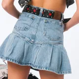 Minifalda de denim celeste con diseño plisado en la parte inferior y bolsillos traseros.