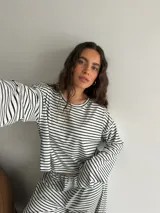 Conjunto compuesto por remera de manga larga y pantalón largo, confeccionados en tejido rib con diseño de rayas horizontales.