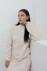 Vestido corto de punto color fucsia, con cuello alto y mangas largas amplias. Diseño holgado y cómodo.