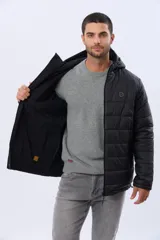 Campera puffer reversible para hombre, de color negro, con diseño capitonado, capucha integrada y bolsillos funcionales con cierre frontal.