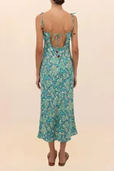 Vestido largo con estampado floral en tonos celeste y azul, de corte recto, escote cruzado con cut out central y breteles finos ajustables.