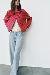 Blazer cruzado de tweed rojo con patrón texturizado en tonos blanco y negro, cuello con solapa, manga larga y cierre frontal con un botón.
