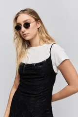 Vestido corto de encaje negro con breteles finos y corte ajustado al cuerpo.