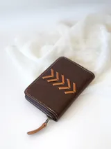 Billetera marrón de cuero con cierre metálico y diseño de espiga.