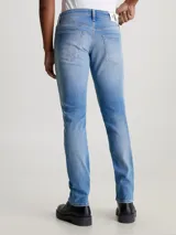 Pantalón de jean celeste con roturas en las rodillas, corte slim, tiro bajo y cinco bolsillos.