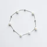 Pulsera de cadena fina en plata 925, intercalada con perlas de río naturales y pequeñas esferas de plata pulida.