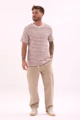 Remera de manga corta con cuello redondo, diseño a rayas horizontales blancas y bordó, y un bolsillo en el pecho.