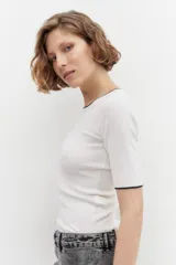 Sweater blanco de punto con cuello redondo y mangas 3/4. Tiene ribete negro en cuello y puños.
