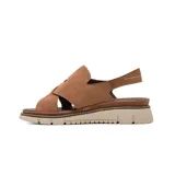 Sandalia plana Korium modelo Adamaris de color beige, confeccionada en gamuza con tiras cruzadas en el empeine, tira ajustable con hebilla metálica dorada y suela dentada en tonos beige y marrón.