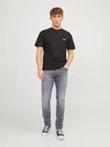 Jean de corte ajustado y tiro bajo, confeccionado en denim gris con acabado lavado. Cuenta con diseño clásico de cinco bolsillos y cierre frontal con botón.