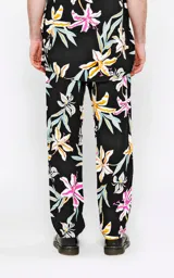 Pantalón recto de calce regular, color negro, con estampado de flores tropicales en tonos blanco, amarillo, rosado y celeste.