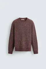 Jersey de punto con textura perlada, corte relajado, cuello redondo y manga larga con puños y ruedo acanalados.