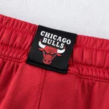 Short deportivo rojo con cintura elástica ajustable con cordón, bolsillos laterales y logo del equipo de baloncesto Chicago Bulls estampado en la pierna izquierda.