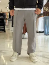 Pantalón jogging oversize de felpa, color gris, de corte recto y diseño cómodo con costuras frontales en relieve.