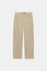 Pantalón de tiro medio con diseño barrel, pernera holgada que se estrecha hacia el tobillo y detalle de raya planchada en el frente y la espalda. Cuenta con cinco bolsillos y cierre frontal con cremallera y botón.
