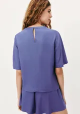 Blusa de manga corta con cuello redondo, confeccionada en tejido de lino con textura natural, de corte recto y ajuste cómodo.