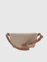 Riñonera de piel bovina en dos tonos: base marrón y solapa color crema. Tiene un compartimento principal con cierre magnético oculto bajo la solapa y un bolsillo interior. Incluye un asa larga regulable para llevar cruzada o como riñonera.