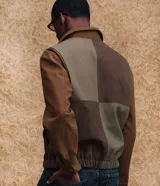 Chaqueta Marfinno de corte recto con diseño de bloques en tonos tierra, confeccionada en poliuretano con base de poliéster. Presenta cuello camisero estructurado, cierre frontal con zíper, mangas largas y forro interior con bolsillo funcional.
