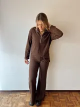 Conjunto de pantalón y buzo de pana marrón. El buzo es de corte holgado con cierre de media cremallera. El pantalón es de corte recto y ancho.