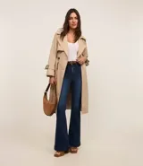 Pantalón de jean acampanado de tiro alto, color azul oscuro, con bolsillos delanteros y traseros, y cierre con botón y cremallera.